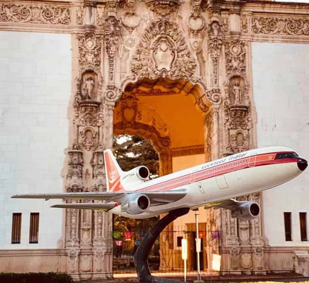 Airplane model displayed in front of historic architectural monument - Quest for Directions.