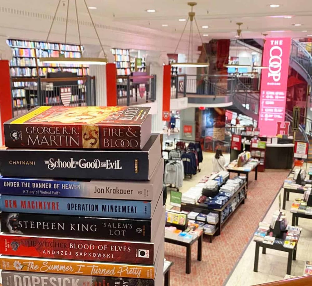1. Wide shot of a bookstore interior showcasing stacked novels and book displays for browsing.