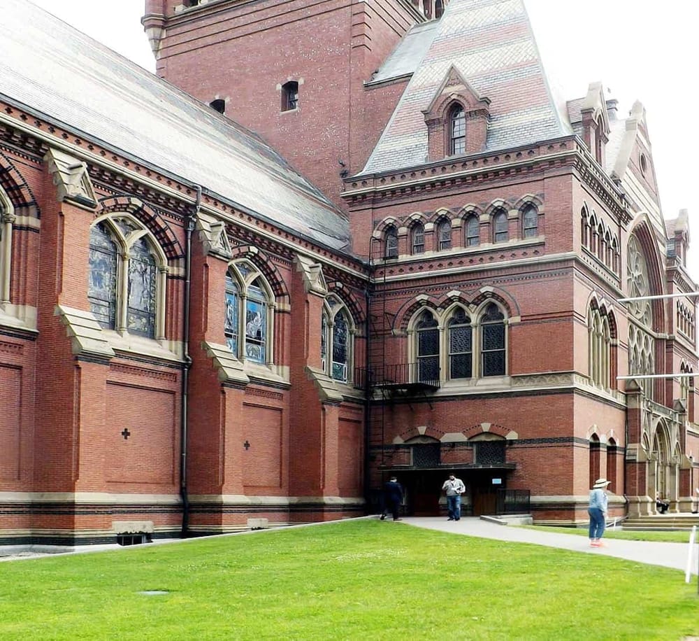 Magnificent Gothic brick church with historic architecture and stained glass windows, visitors exploring its exterior.