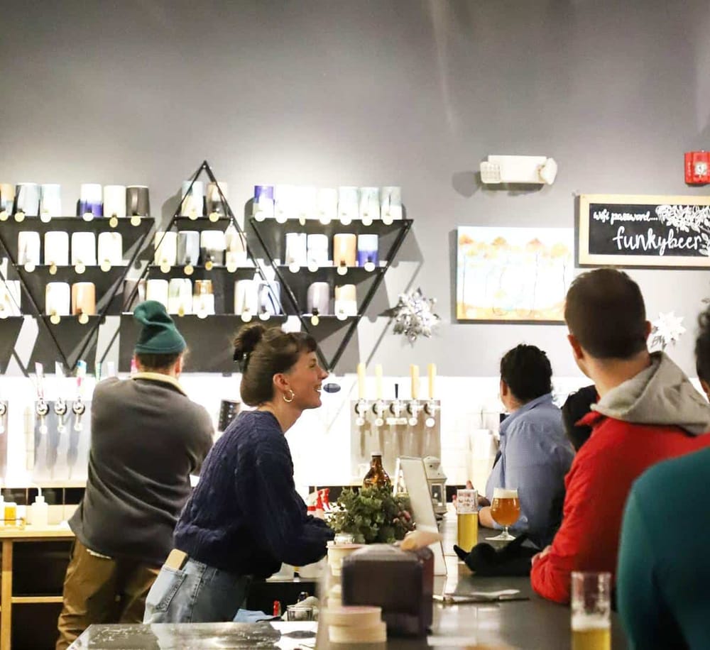 Relaxed bar scene at QuestForDirections with customers enjoying drinks and engaging conversations in a modern, inviting atmosphere.