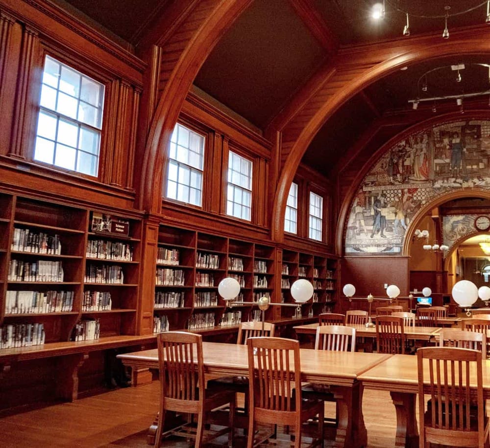 History library with wooden interior and large windows, perfect for research and learning.