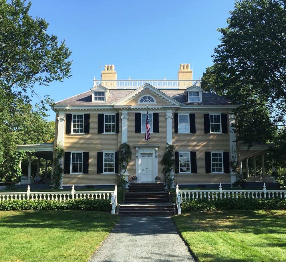 Charming historic house with classic architecture, lush greenery, and welcoming exterior, perfect for home tours.