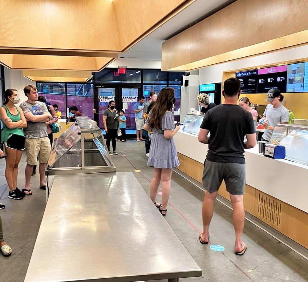 Delicious ice cream shop with customers, modern interior, and digital menu boards. Perfect for dessert and ice cream lovers.