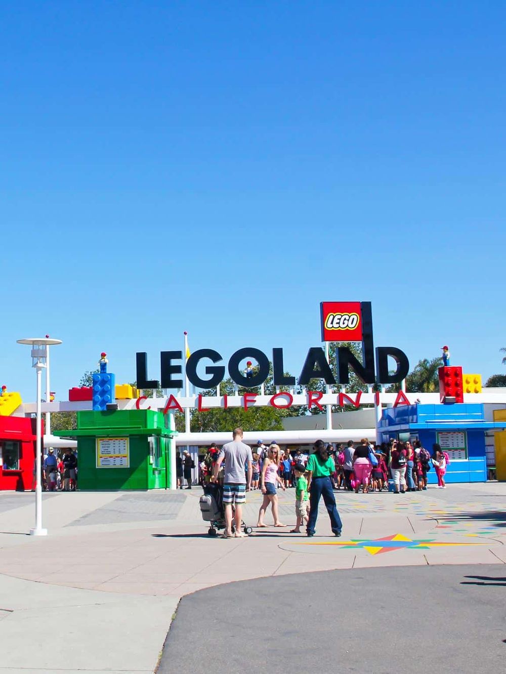 Lego Land California entrance with colorful Lego sculptures and visitors, showcasing family-friendly amusement park.