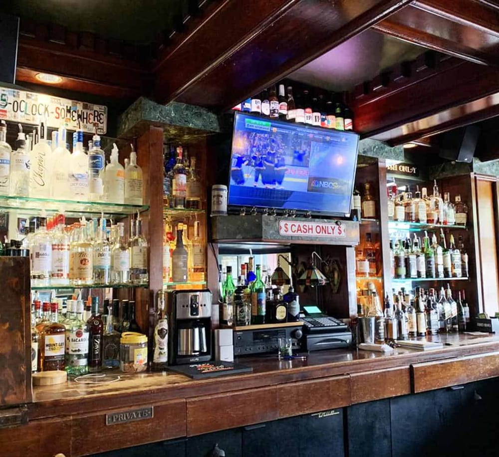 1. Wide shot of a bar with liquor bottles and TV screen.