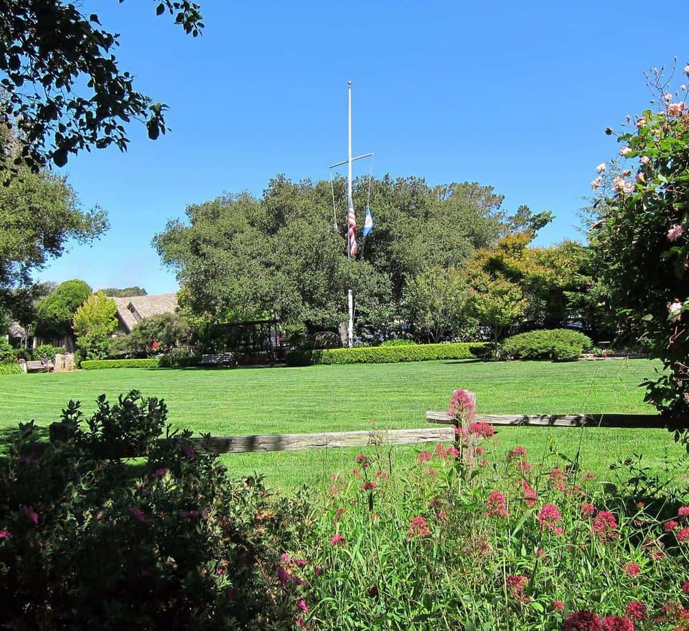 Lush green park with flagpole and vibrant flowers, perfect for community gatherings and outdoor activities.