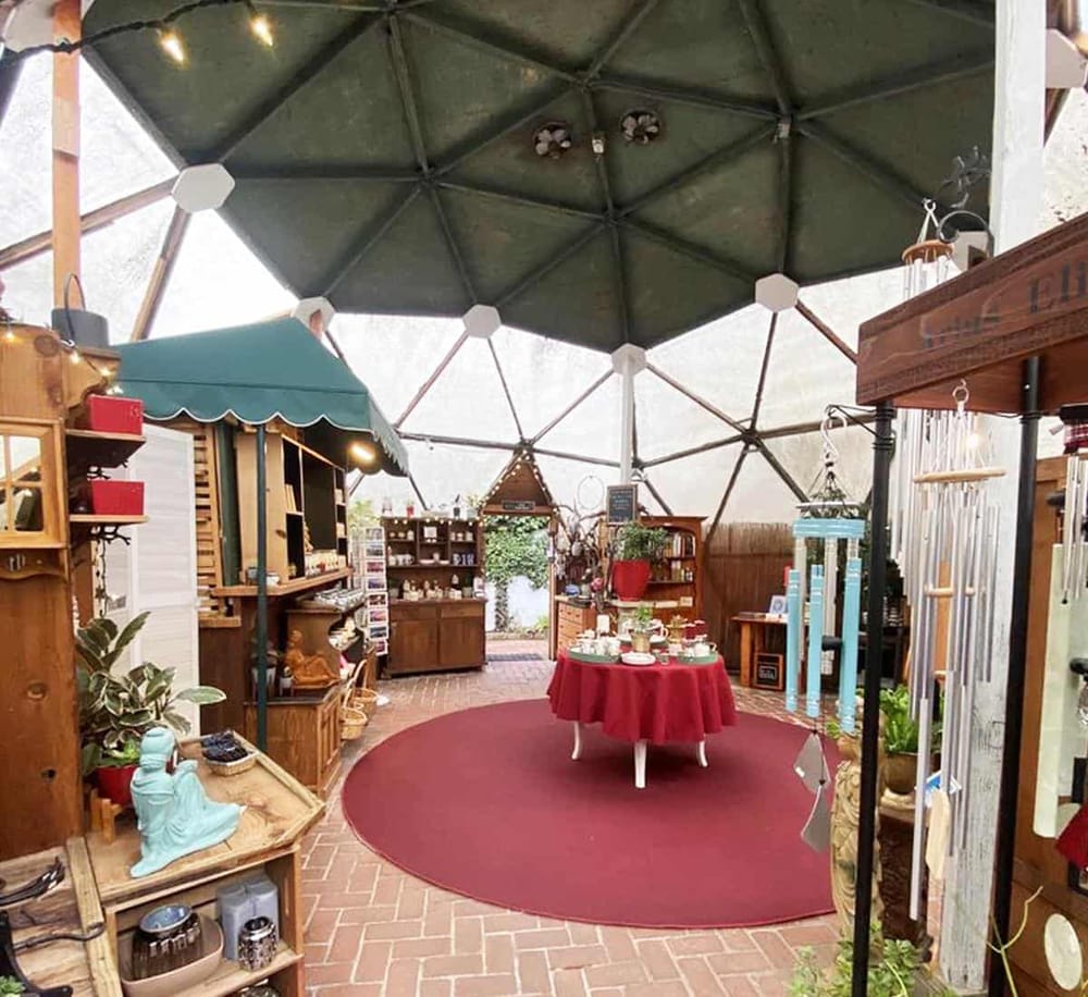 Colorful indoor gift shop with vintage decor and unique handmade items under a geodesic dome ceiling.