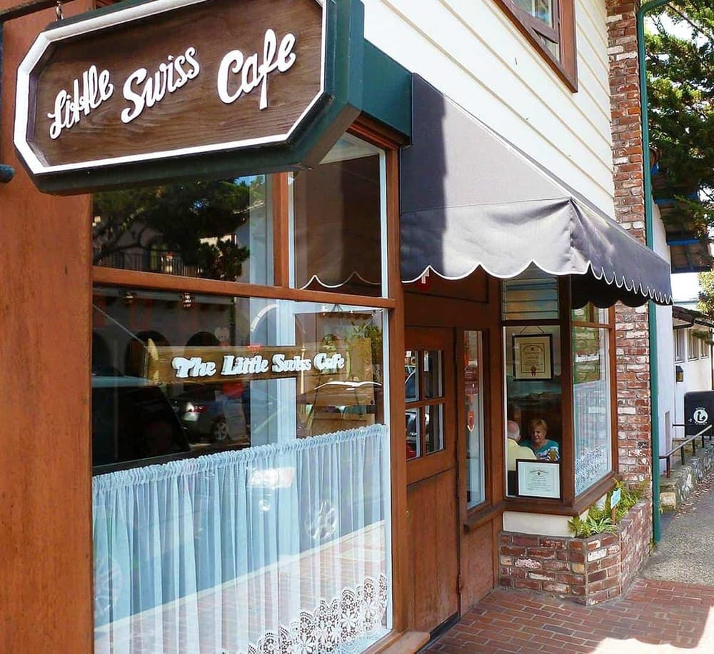 Charming Little Swiss Cafe exterior with wooden accents and classic awning, perfect for cozy dining experience.
