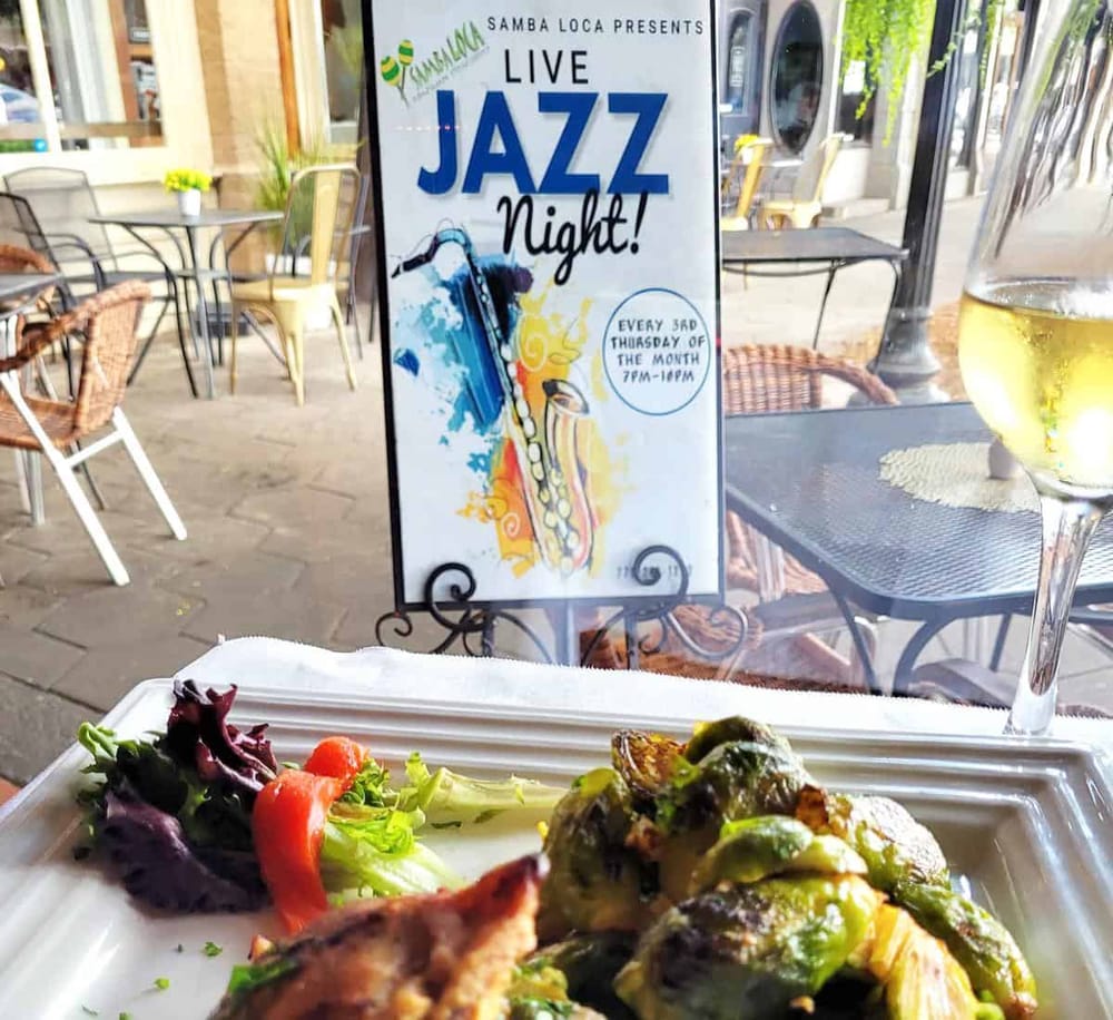 Vibrant Jazz Night poster at outdoor cafe with tasty Brussels sprouts and salad dish.