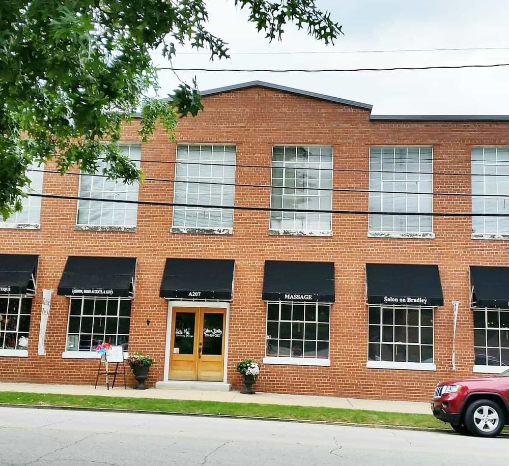 Modern brick commercial building with salon and massage services, accessible location, storefront windows, and street parking.