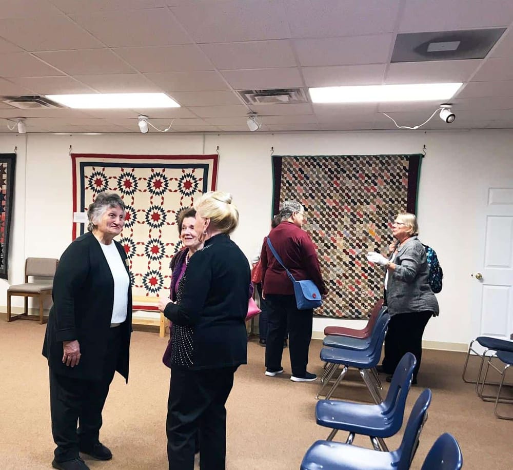 Colorful quilts displayed at a community event or gathering.