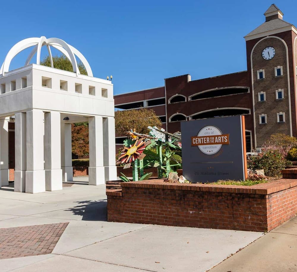 Modern Arts Center building in Carthage, Missouri, with colorful outdoor sculptures and clear blue sky.