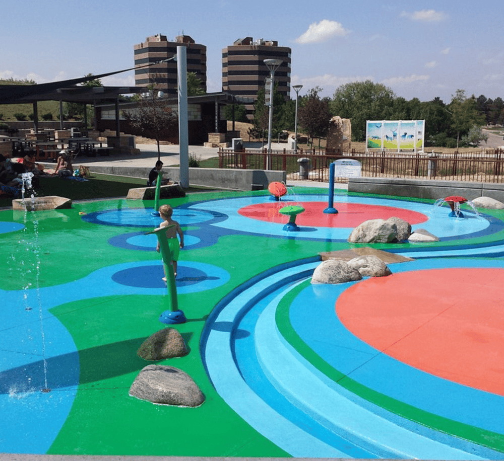 Colorful splash pad water play area for kids at QuestForDirections outdoor attraction.