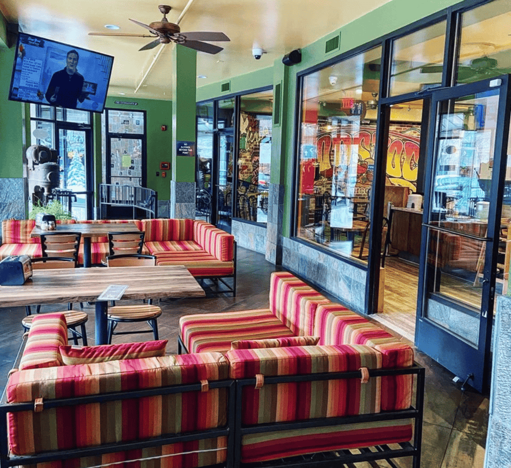 Comfortable restaurant interior with colorful striped seating and modern decor for dining and socializing.