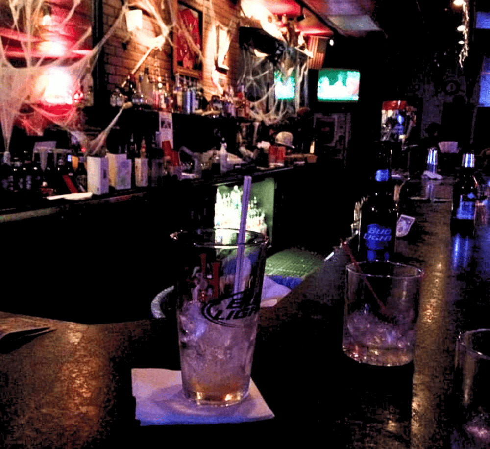 Spider webs and Halloween decorations in a dimly lit bar or pub setting.