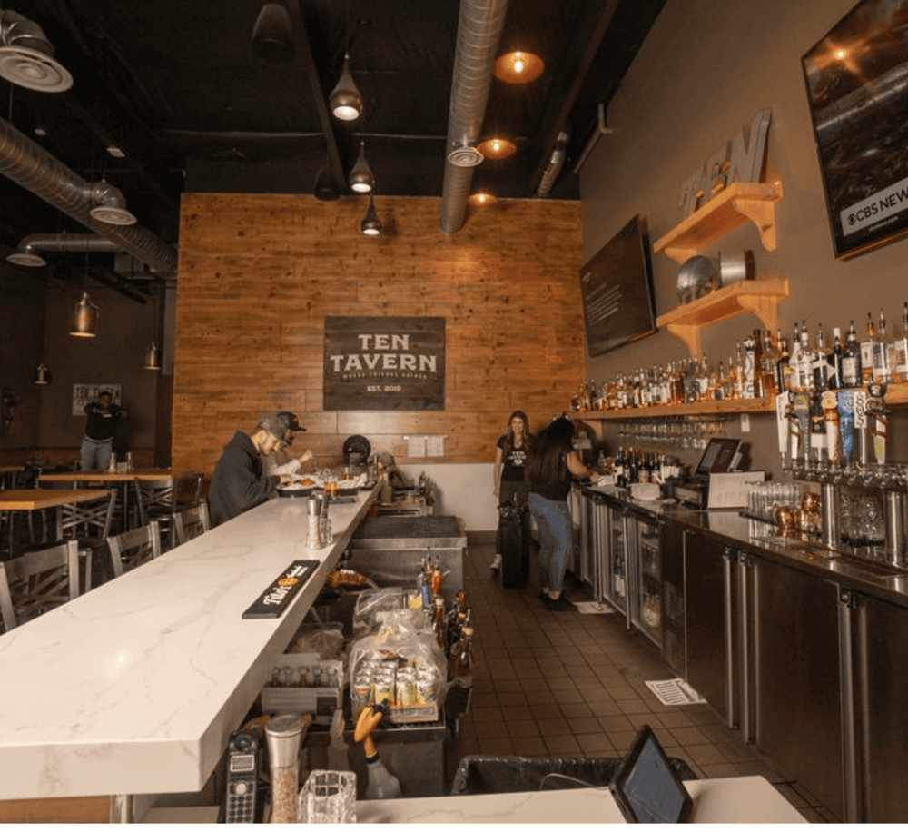 Cozy bar interior at Ten Tavern with extensive drink menu and warm atmosphere for social gatherings.