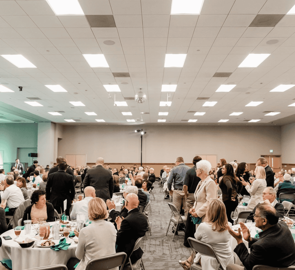 Conference room event space with people seated at round tables, ideal for business and corporate events.