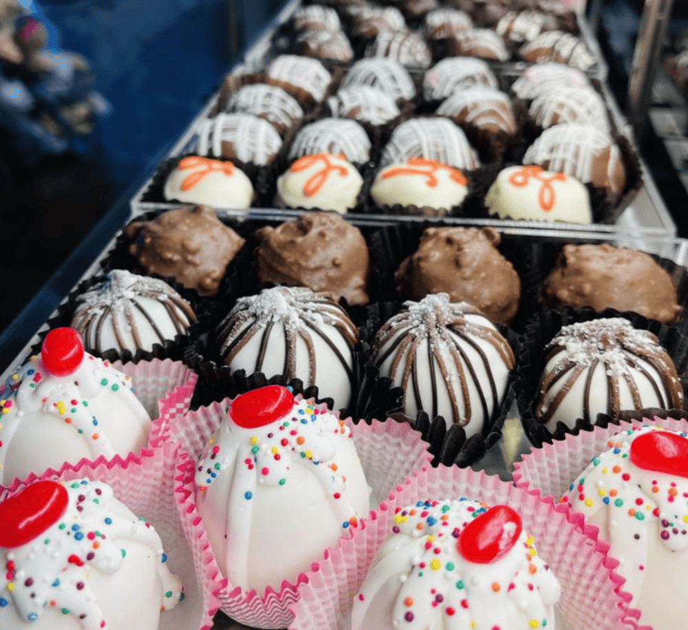 Silky assorted truffles and chocolates displayed at a dessert shop for indulgent treats.
