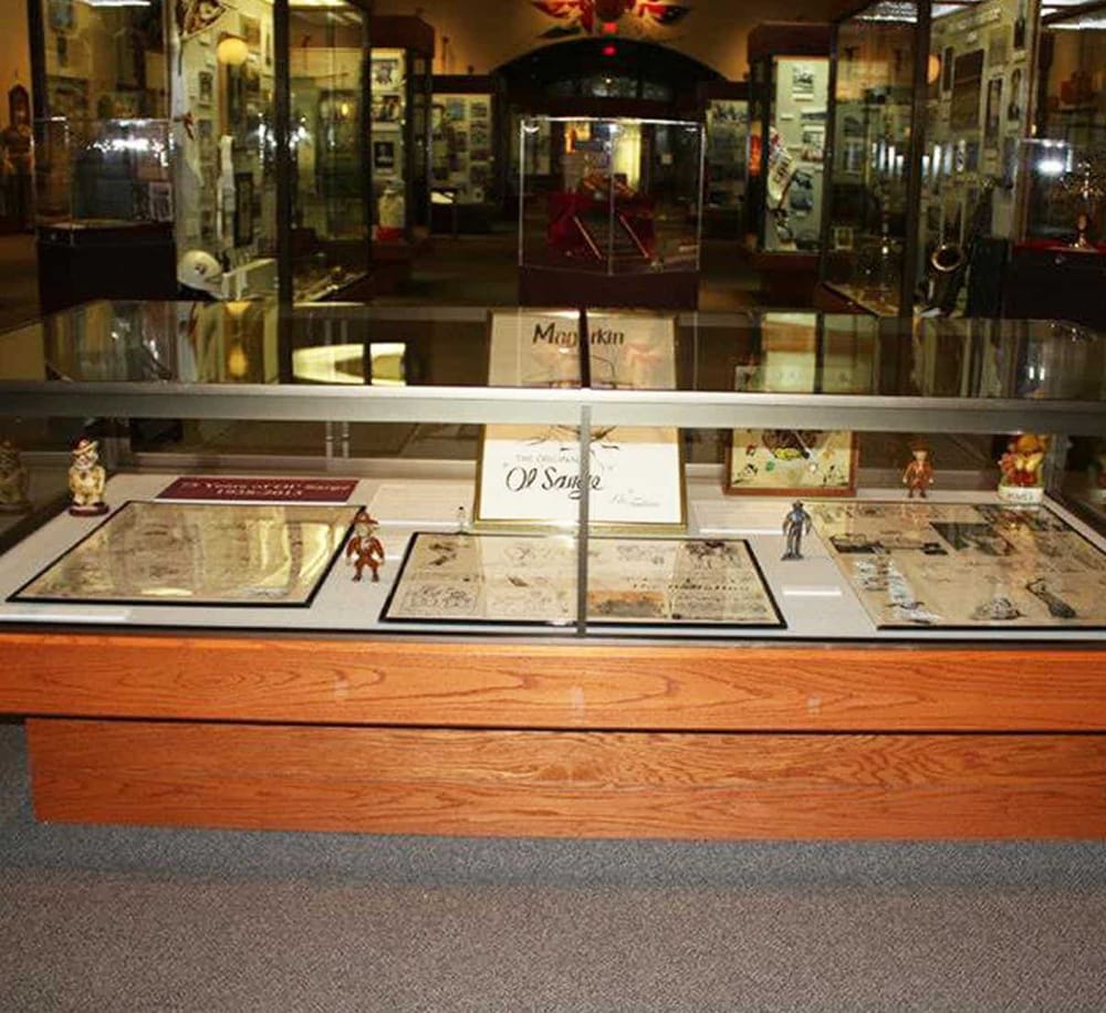 Antique paper collectibles display case at QuestForDirections museum, showcasing historical documents and memorabilia.