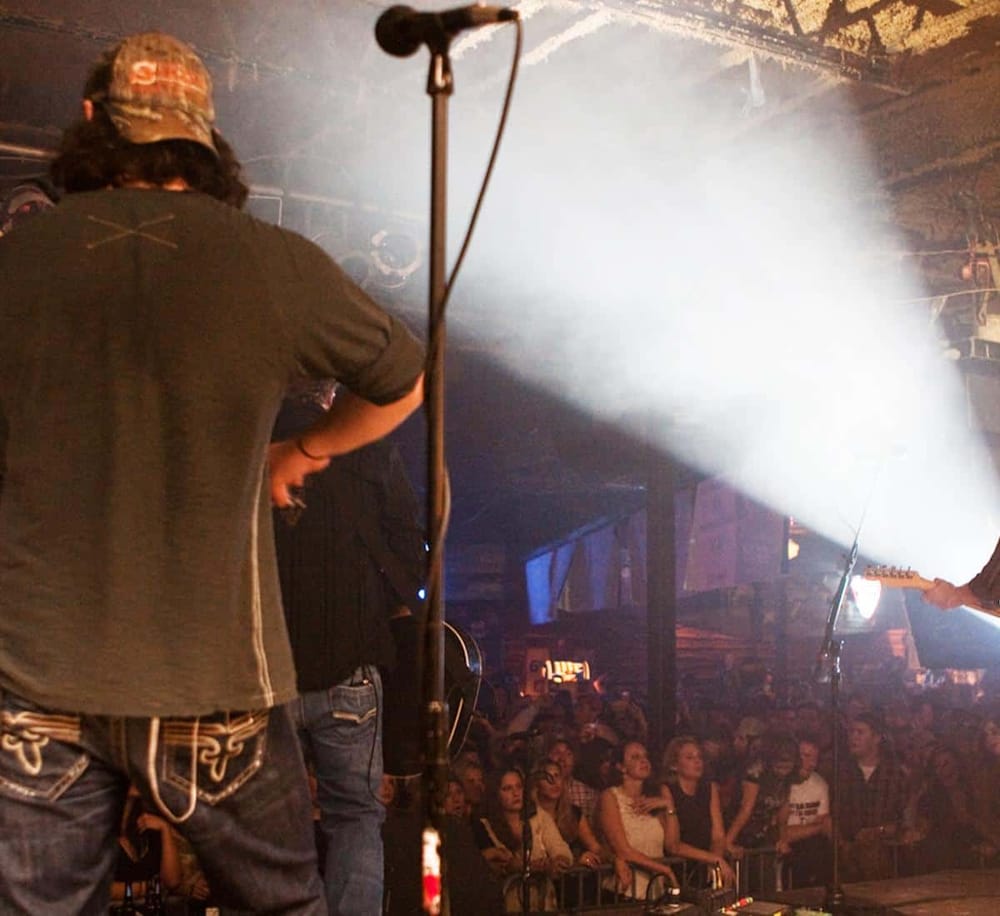 Energetic live music performance at a concert venue with audience Engagement and stage lighting.