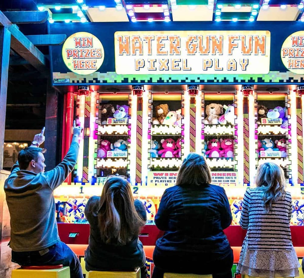 Claw machine arcade game with plush toys at QuestForDirections amusement center.