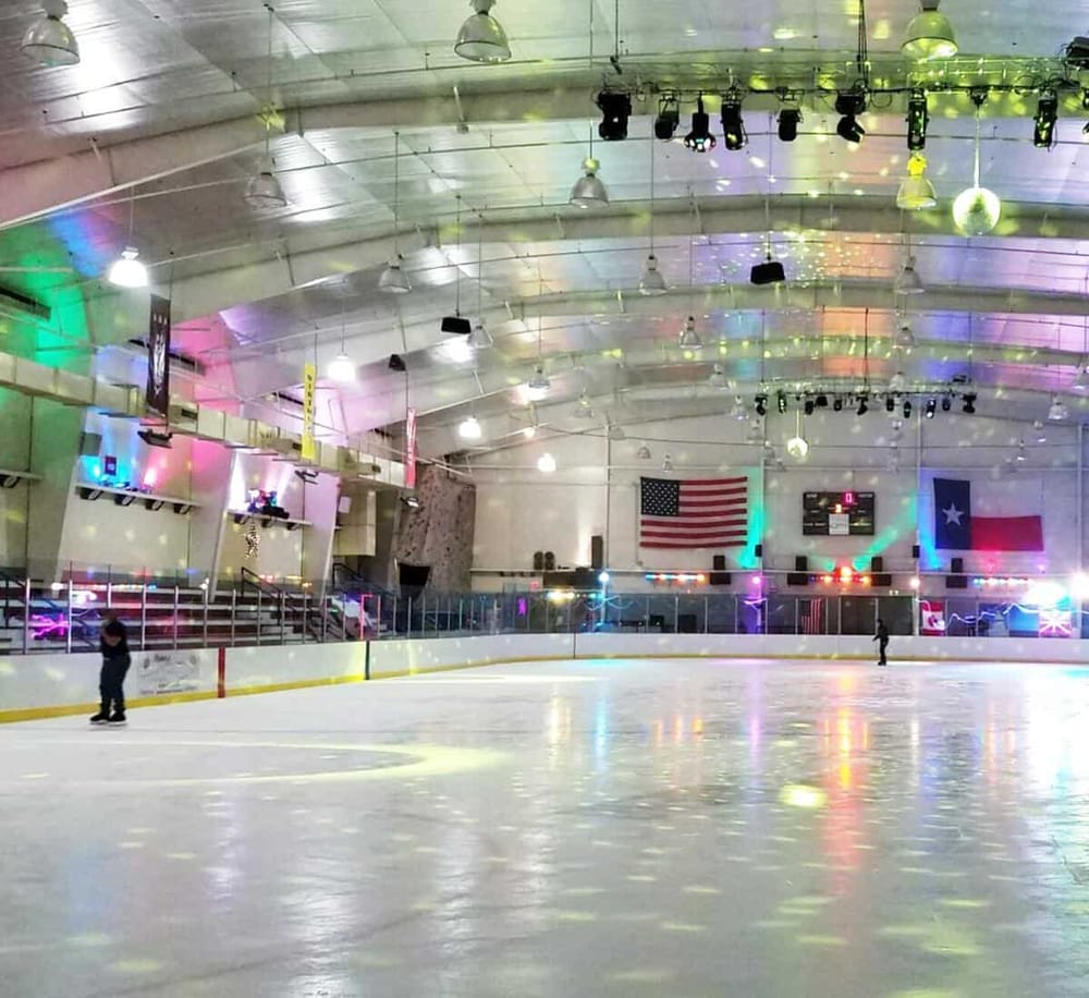 Ice skating rink with colorful lighting and American flag. Perfect for fun winter activities and family entertainment.