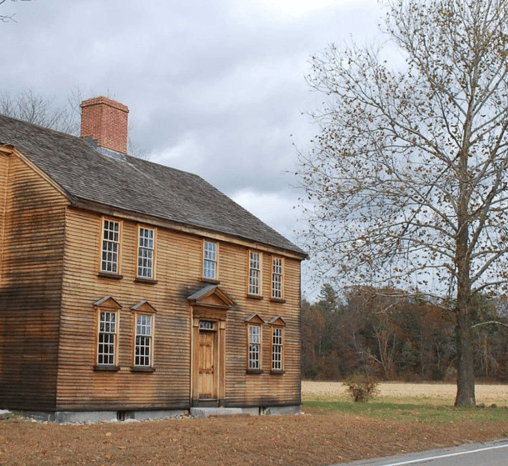 Historic wood-constructed house with autumn trees, ideal for travel and navigation inspiration.