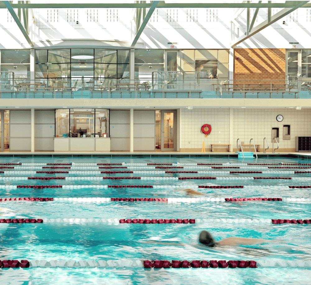 Indoor swimming pool at Quest for Directions, modern fitness and wellness center, bright and inviting sports facility.