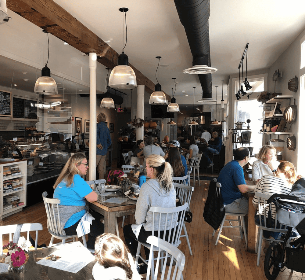 Warm, inviting interior of a cozy café with customers enjoying meals and drinks, perfect for casual dining and socializing.