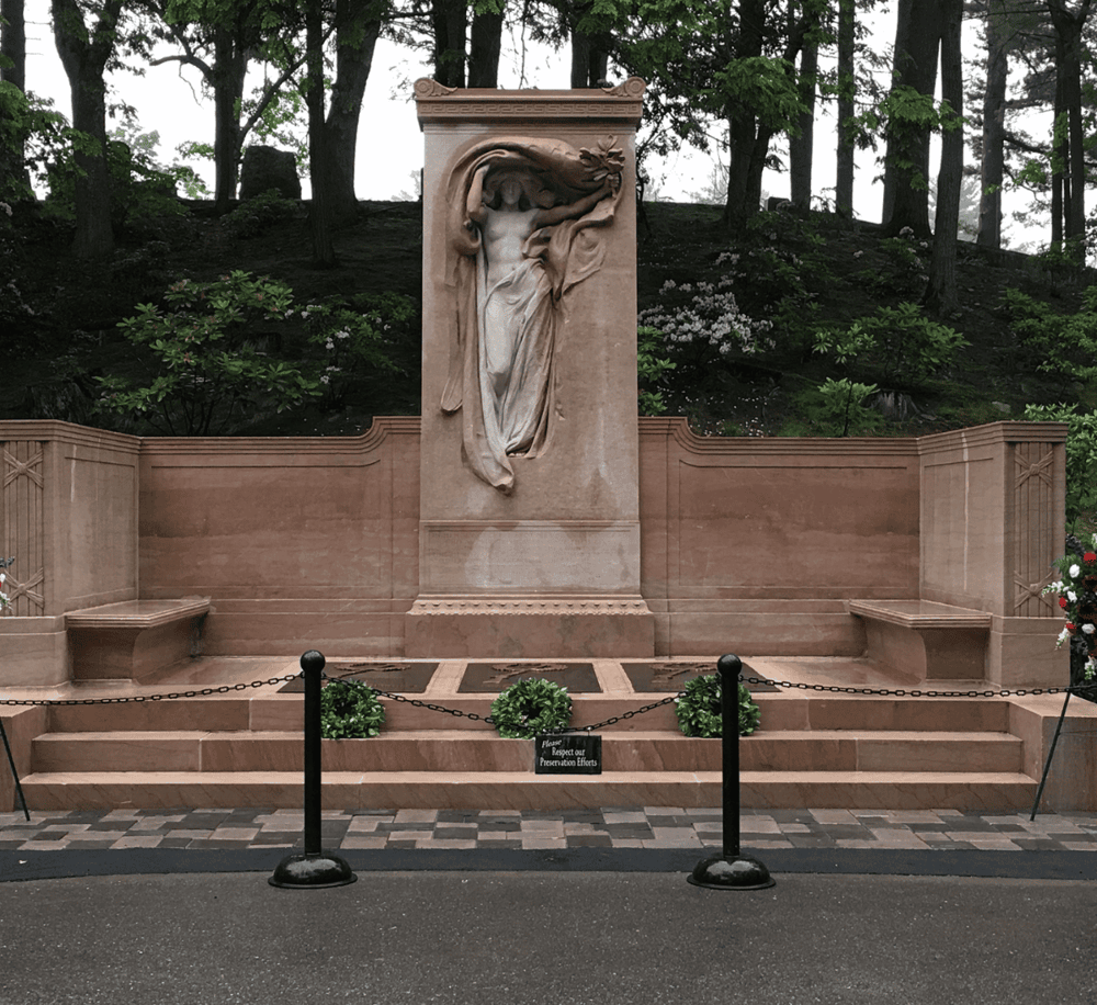 Serene memorial with artistic sculpture in park setting for peaceful reflection and historical remembrance.