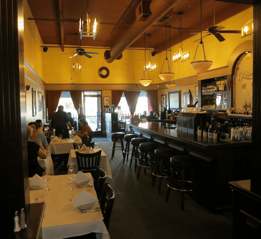 Cozy indoor restaurant with elegant decor, dining tables, bar area, and ambient lighting. Perfect for a dining experience at Quest For Directions.