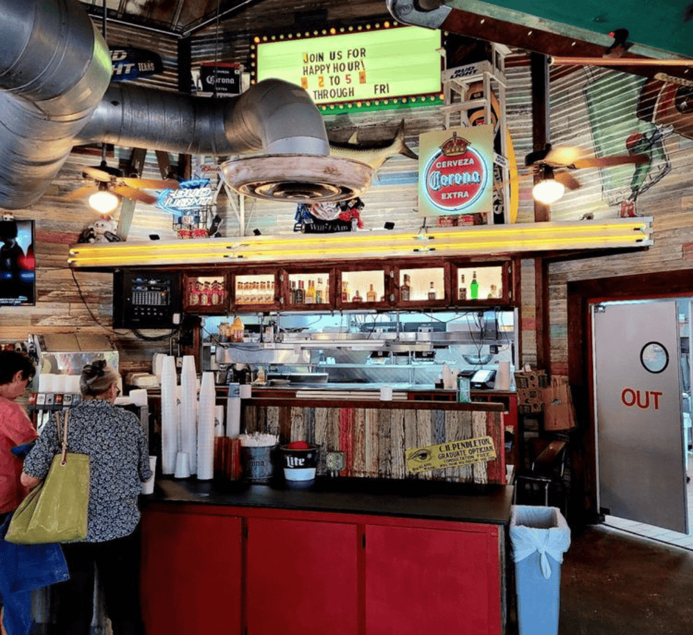 1. Vibrant bar interior featuring beer signs, neon lights, and customers enjoying drinks and snacks.