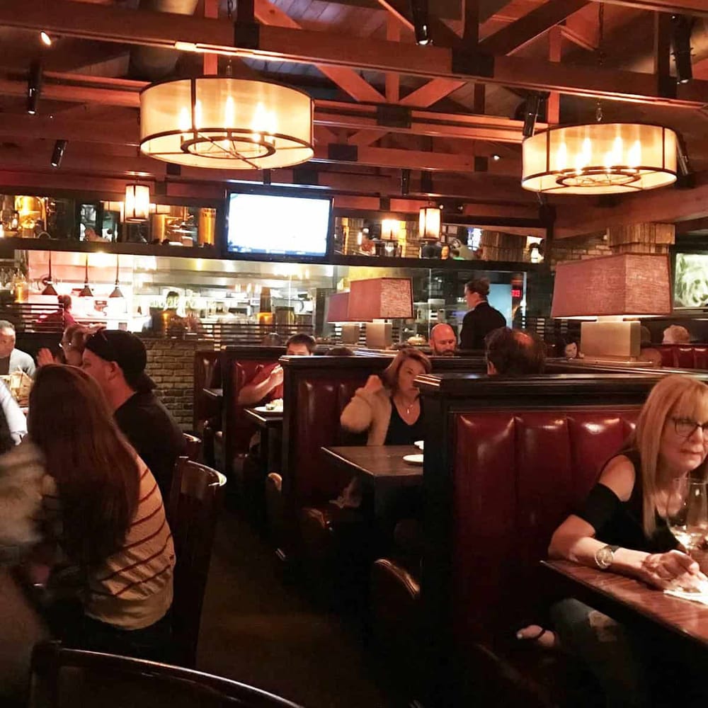 Cozy restaurant interior with warm lighting, wood accents, and diners enjoying meals, perfect for a memorable dining experience.