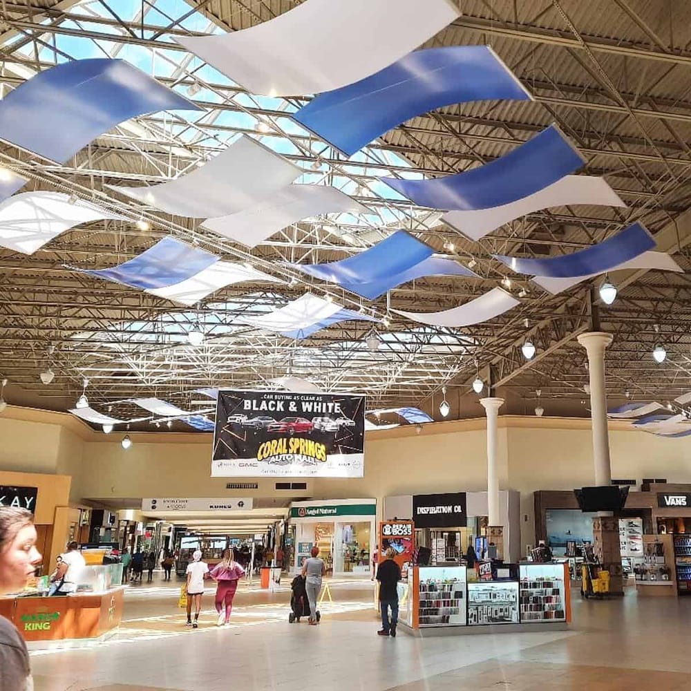 Colorful ceiling decor at Valley International Airport, Texas, with shopping and departure areas.