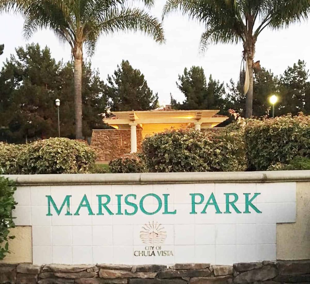 Lush park entrance with Marisol Park sign in Chula Vista, surrounded by palm trees and greenery.