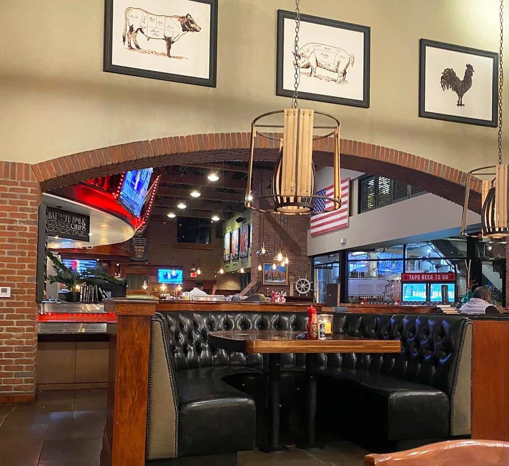 Cow and pig sketches wall decor in a rustic restaurant interior with cozy booth seating.