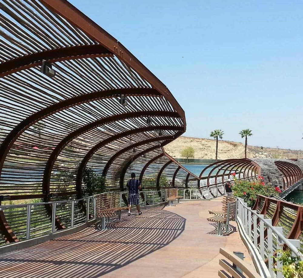 Covered outdoor walkway with modern wooden design, scenic desert landscape in background.