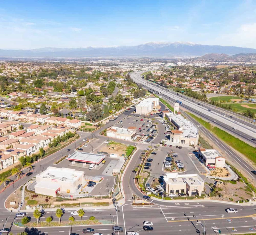 Aerial view of a suburban commercial area with surrounding neighborhoods and highways.