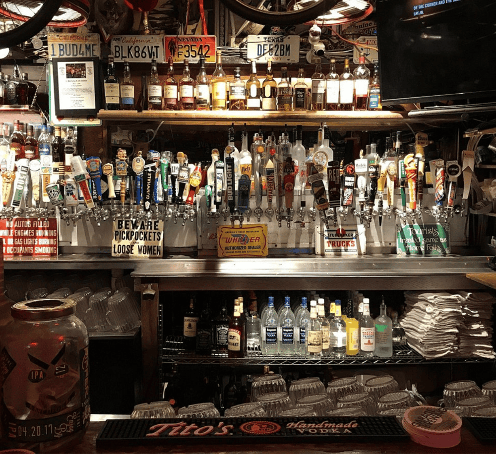Colorful bar with a variety of beer taps and liquor bottles in a cozy pub setting.