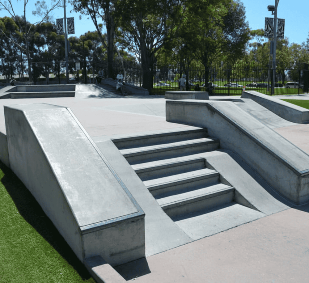 Concrete skatepark ramps and stairs for skating fun and tricks.