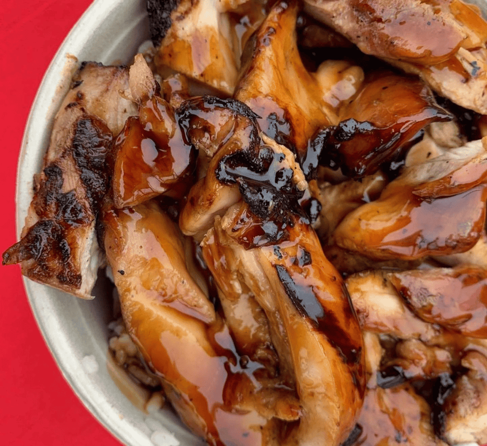Juicy grilled chicken with barbecue sauce on a white plate, perfect for comfort food.