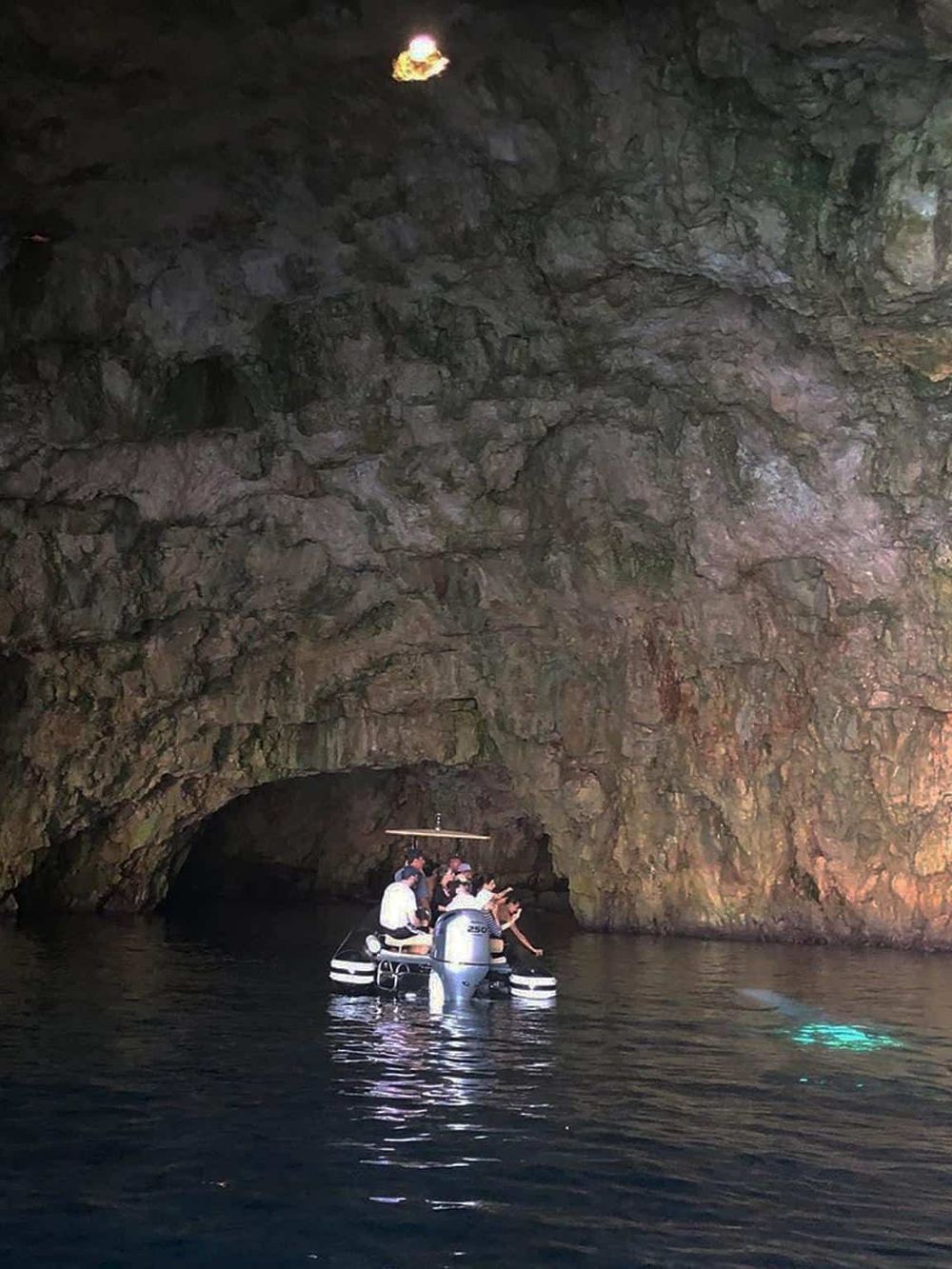 Hidden cave exploration with boat tour inside a natural underground cavern. Adventure and scenic views in a unique geological setting.