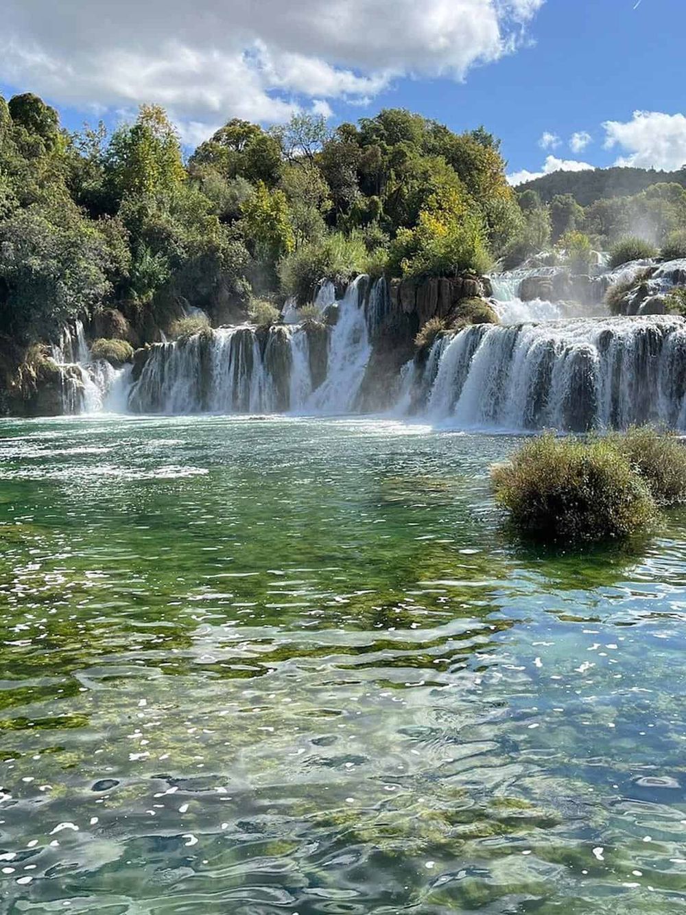 Tranquil waterfall and lush greenery at QuestForDirections nature spot.