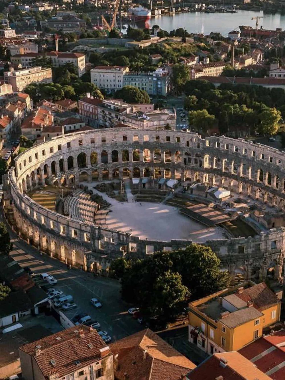 Ancient Roman amphitheater in a scenic cityscape, popular tourist destination in Italy.