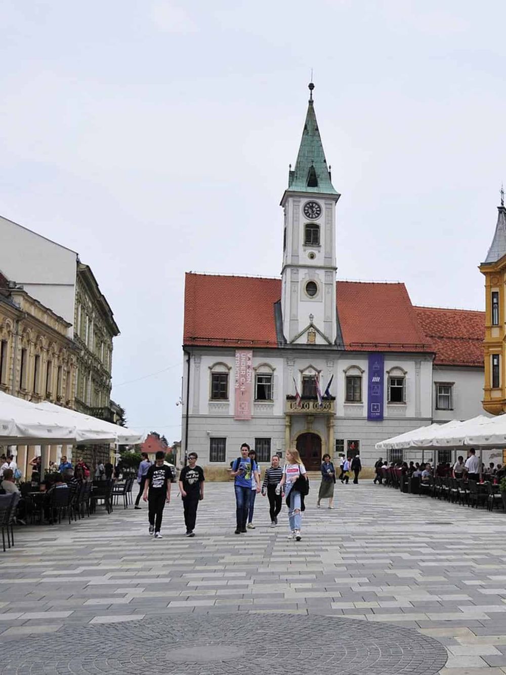 Historic town square with clock tower and outdoor cafes, perfect for guided tours and exploring local culture.
