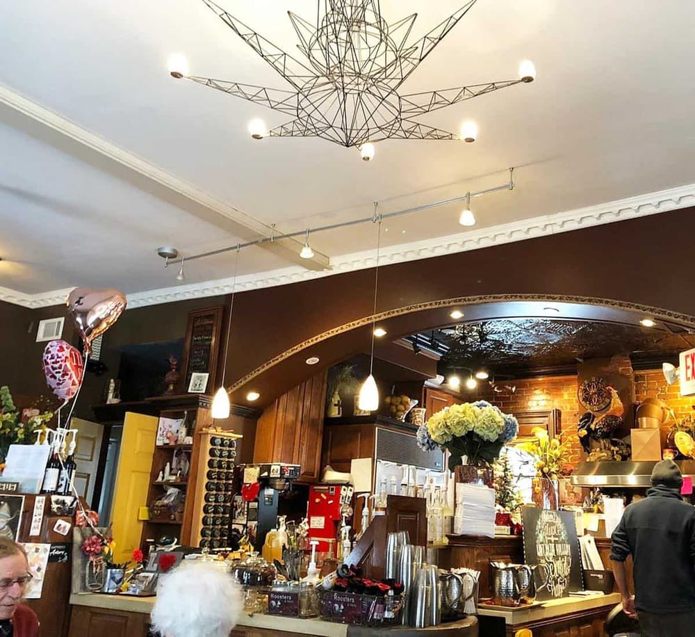 Chandelier with star shape design hanging in a cozy cafe or restaurant interior.