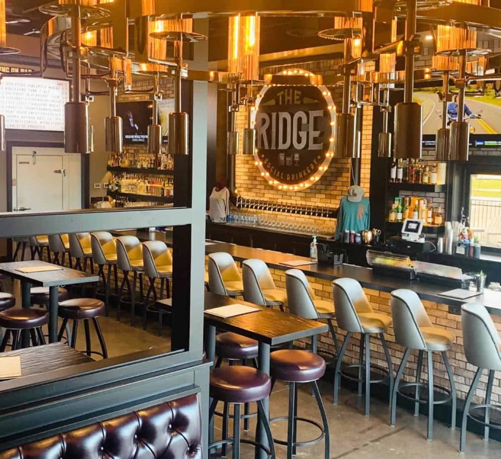 Cozy bar interior at The Ridge Social Deli featuring modern seating and warm lighting, perfect for socializing.