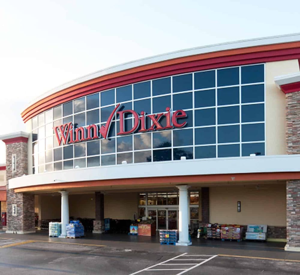 Large Winn-Dixie supermarket storefront with modern architecture and reflective glass windows.