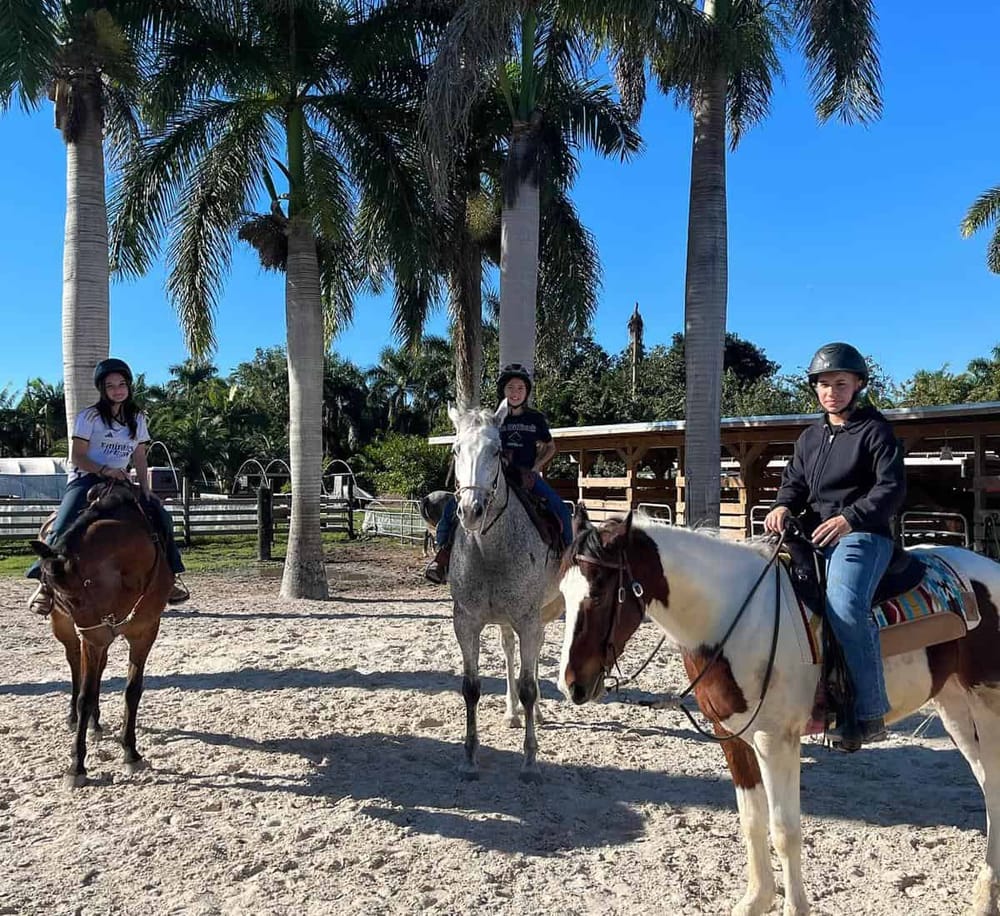 Horse riding adventure at Quest For Directions, scenic outdoor trail with young riders and lush tropical surroundings.