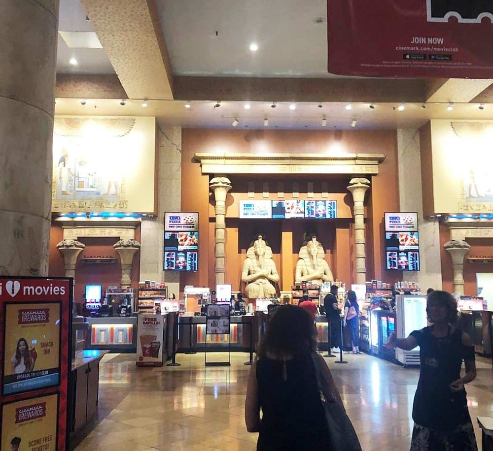 Ancient Egyptian-themed cinema concession stand with movie posters and digital screens.